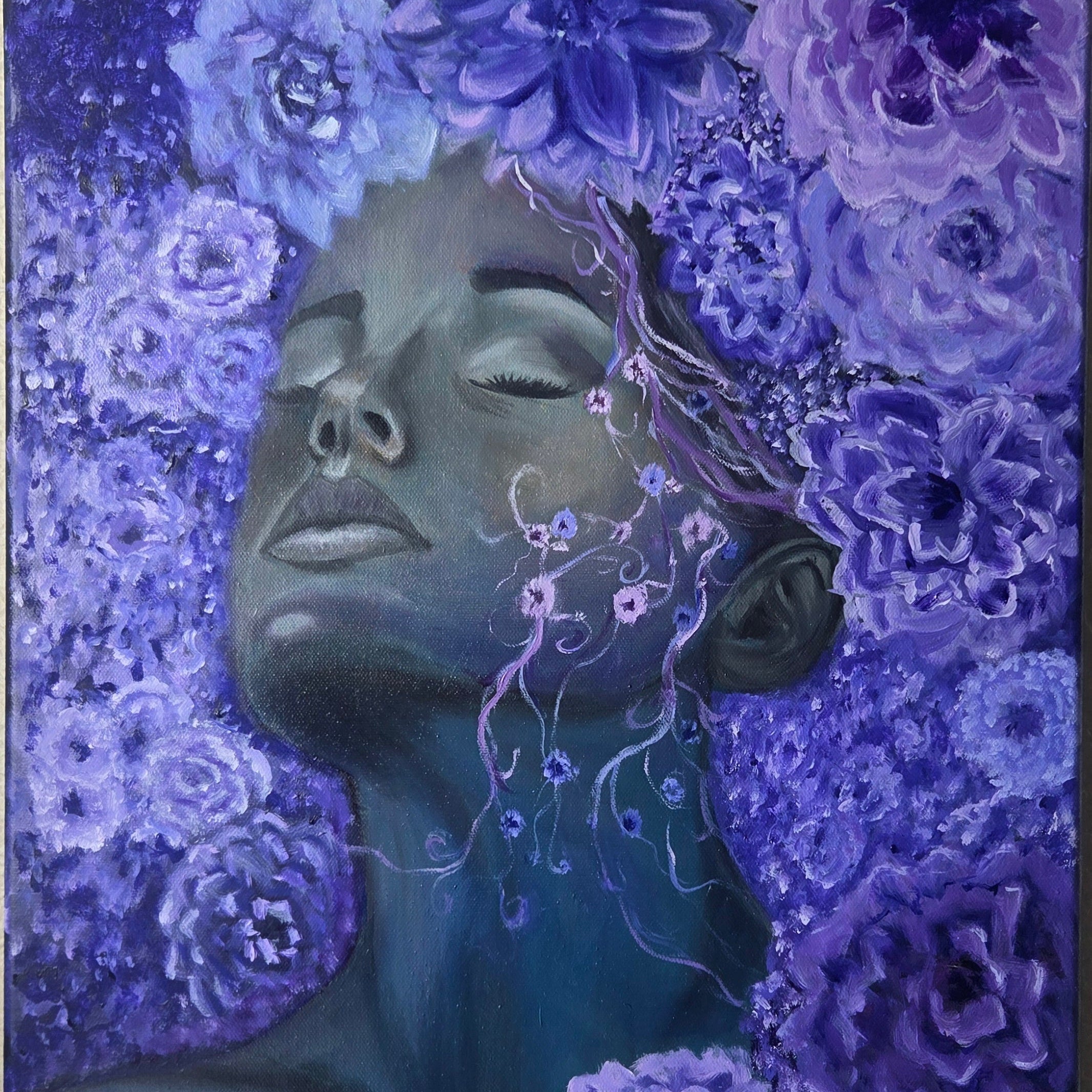 A surreal painting of a woman's face and neck surrounded by dense purple and blue flowers, with her eyes closed and delicate vine-like floral details flowing from her hair.