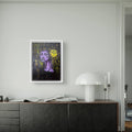 Artwork on a wall of abstract textured art featuring a woman in purple and a yellow flower.